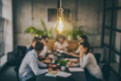 An image showing people sitting around a table to discuss new ideas. 